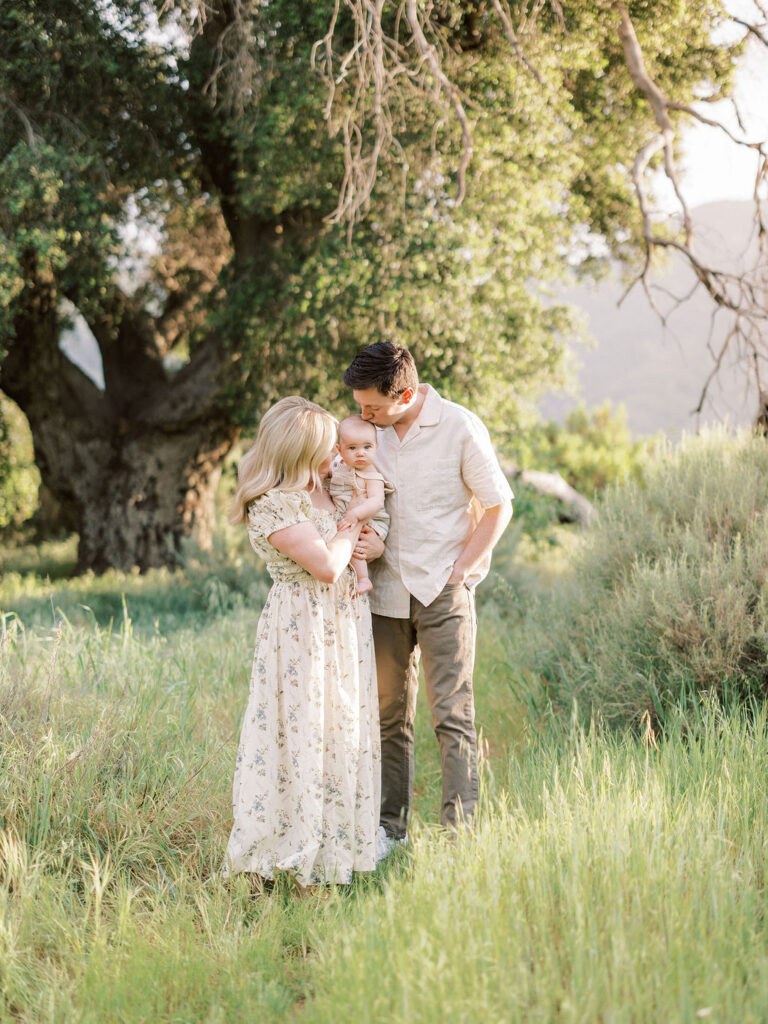 Family gathered together in a sunlit meadow during a spring photo session in Santa Clarita.