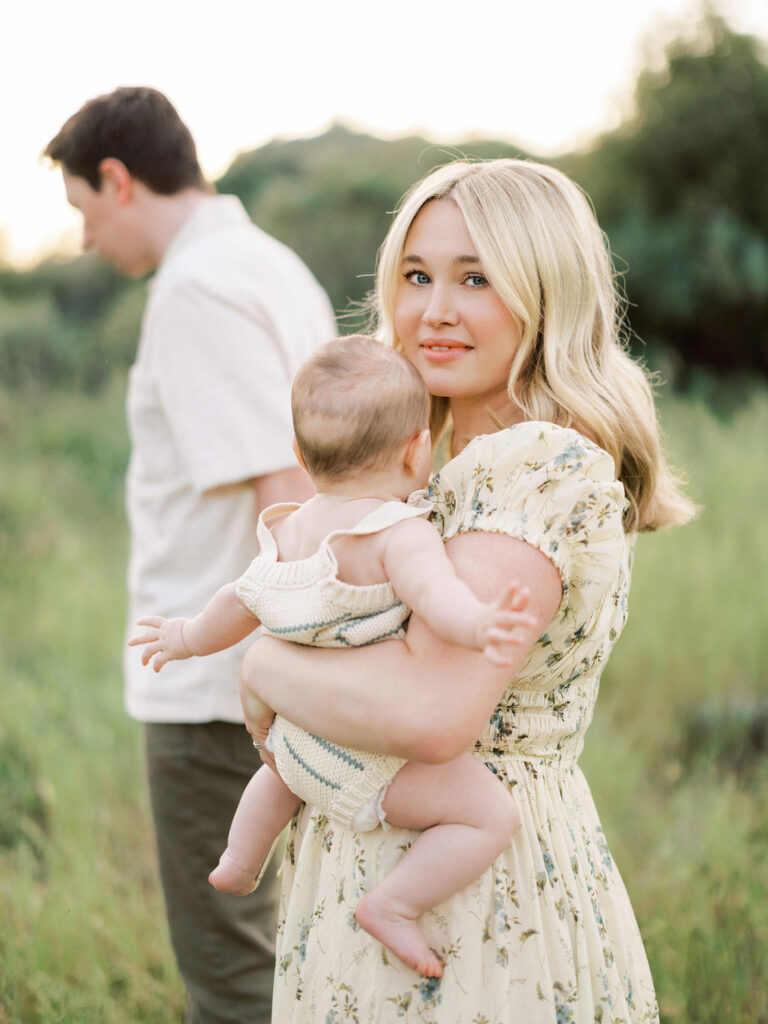 Mother holding her baby during a relaxed spring family photo session outdoors.