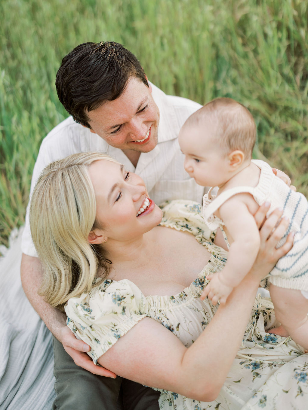 Parents cuddling and smiling with their baby during a family photo session in Santa Clarita, California.