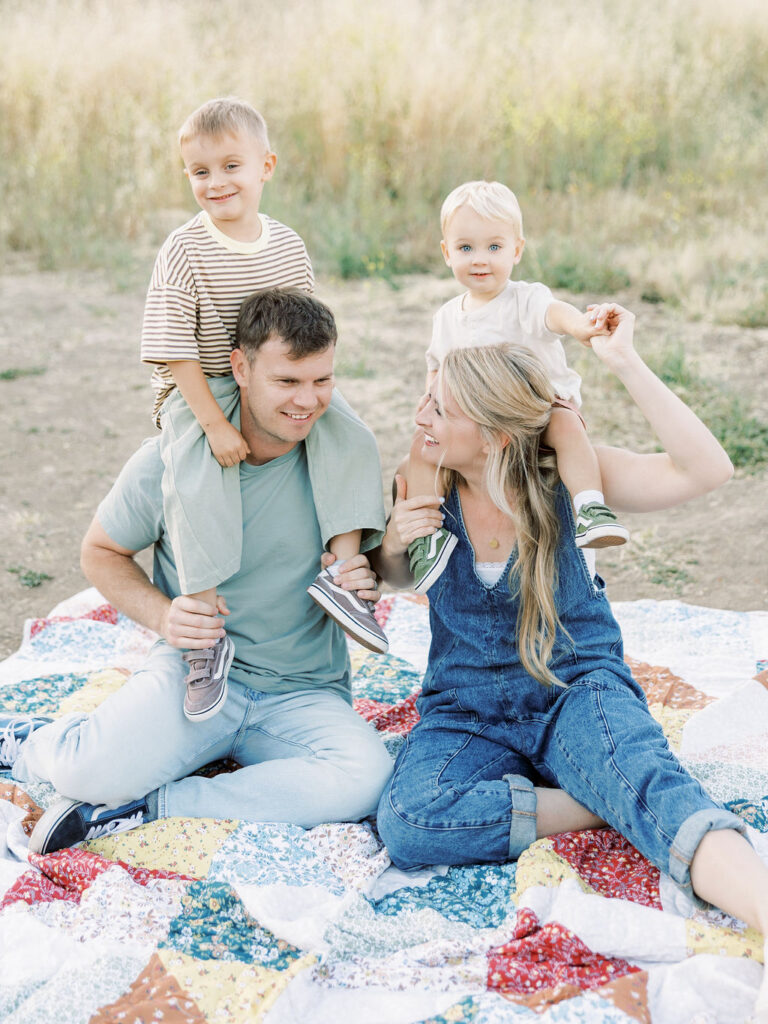 Parents sitting together with their toddlers during a natural outdoor family session