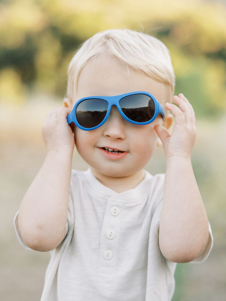 Toddler wearing sunglasses during fun family photos with toddlers