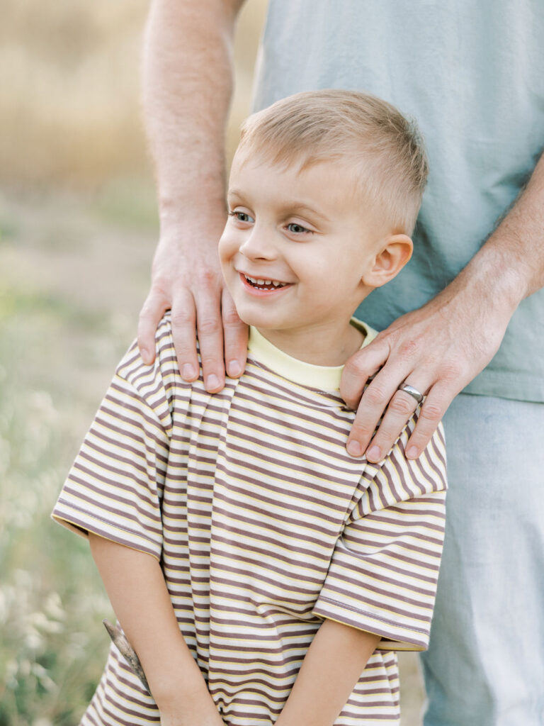 Smiling toddler standing outdoors during a natural family photography session