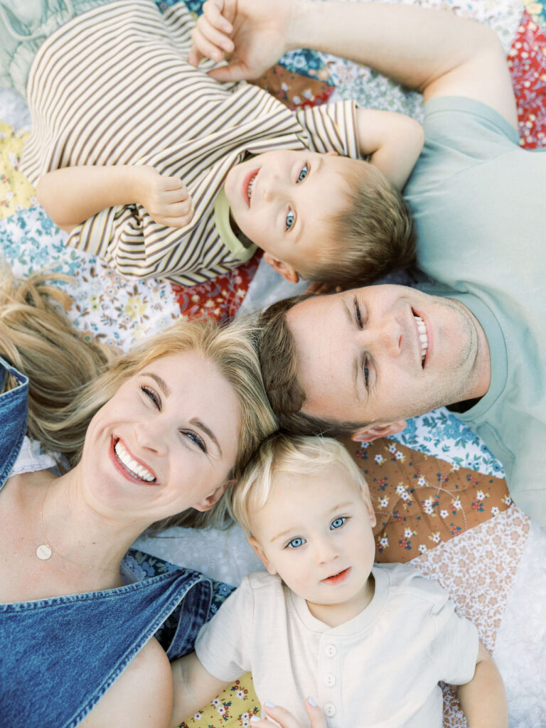 Parents lying in the grass with their toddler during relaxed family photos with toddlers in Santa Clarita