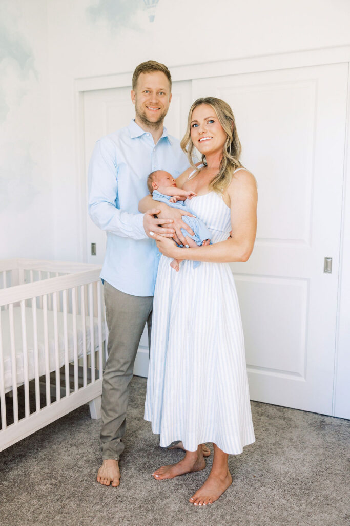 Mom standing and holding her baby during in-home newborn photography Santa Clarita.