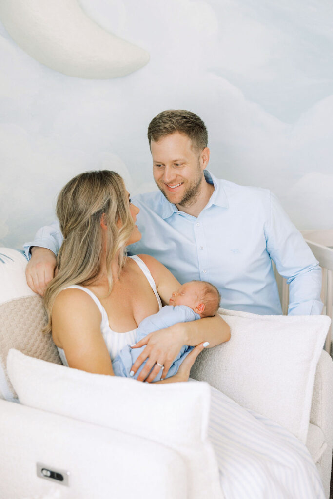 Mom and dad sharing a quiet moment with their baby during in-home newborn photography Santa Clarita.