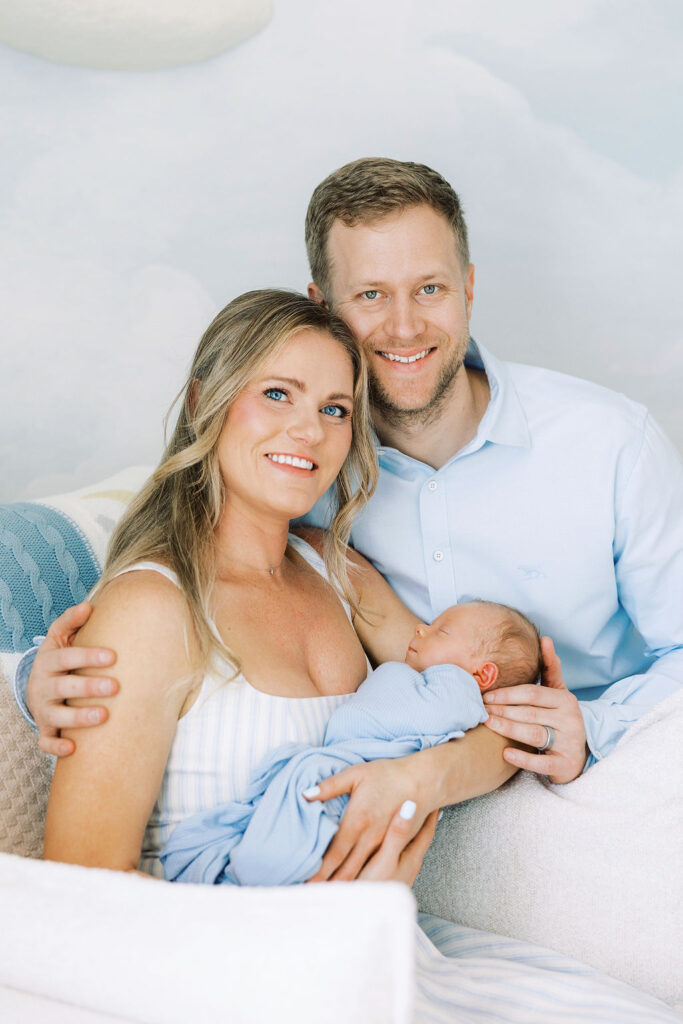 Mom and dad holding their newborn together during a natural newborn session at home.