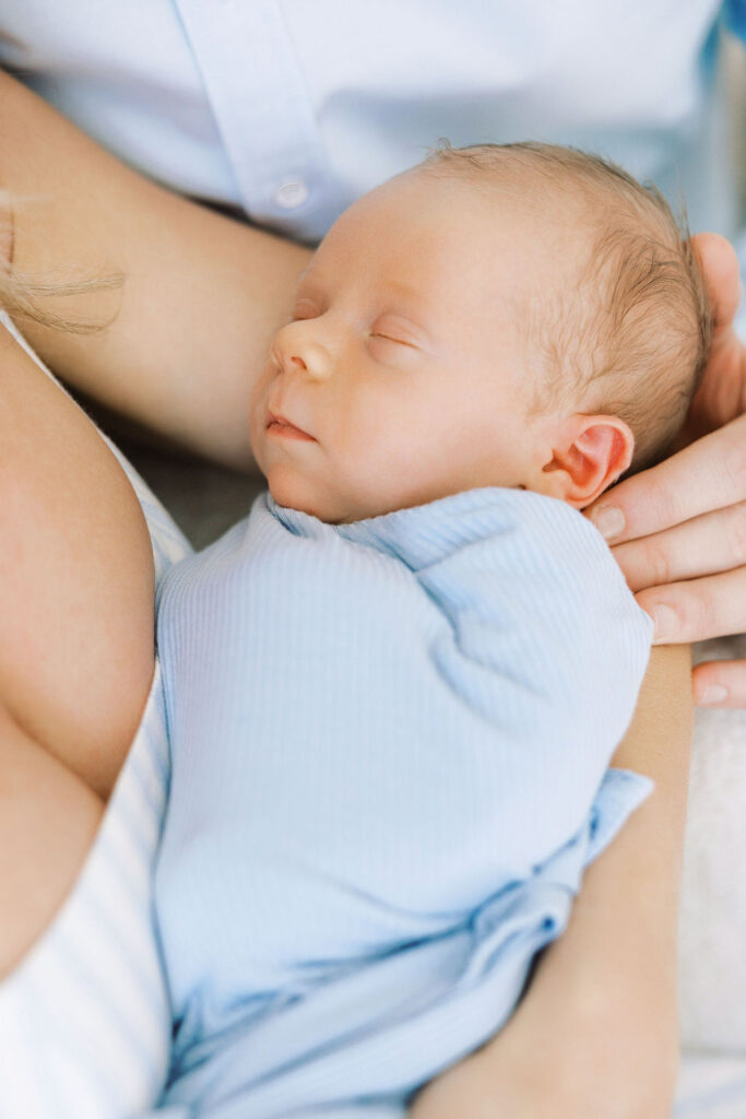 Close-up of a newborn resting peacefully against mom.