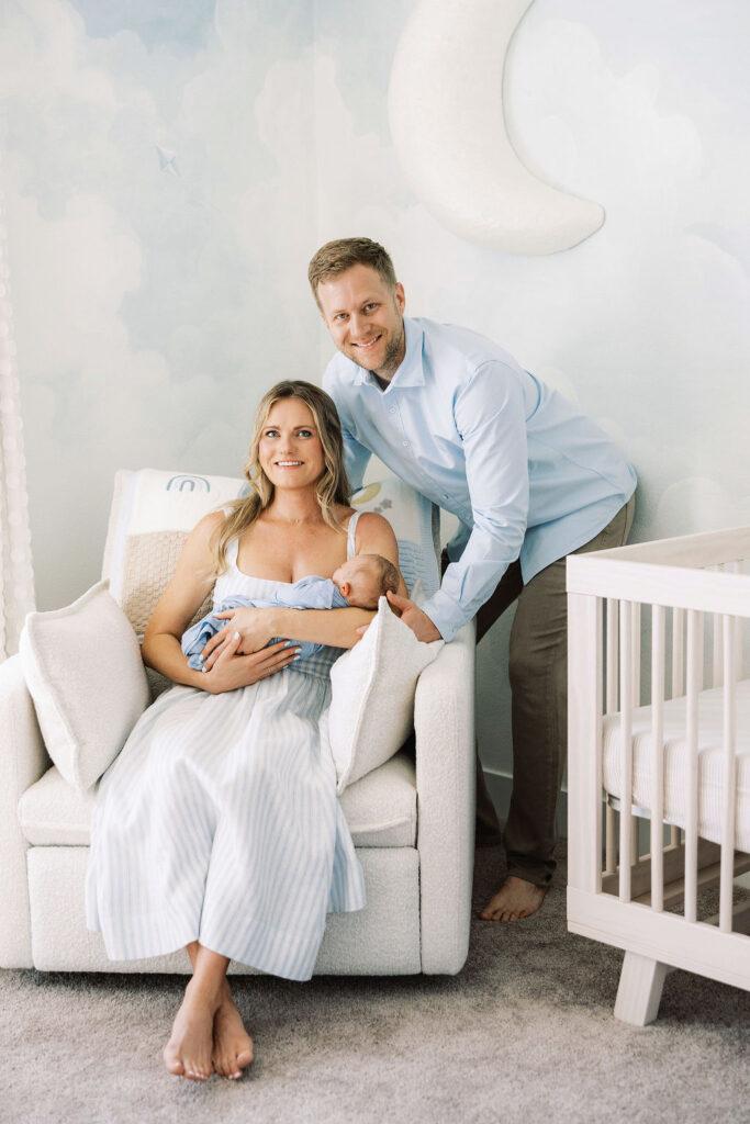 Family of three together beside the nursery crib during an in-home newborn session.