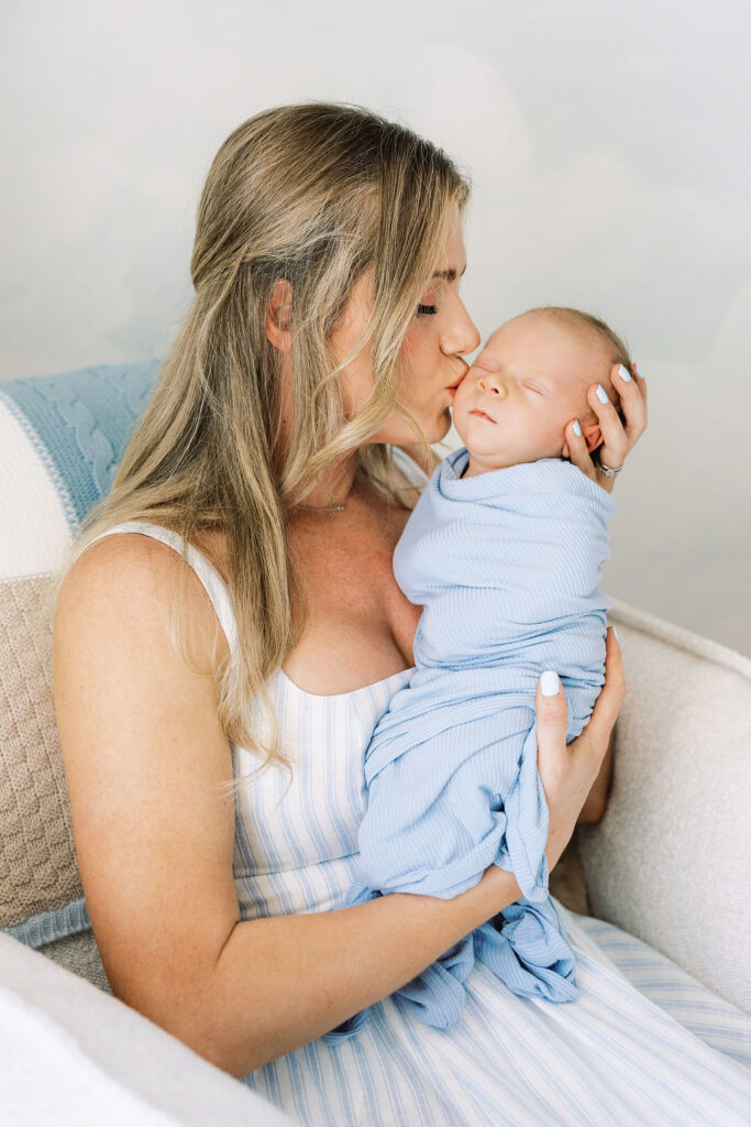 Mom holding her baby close during in-home newborn photography Santa Clarita.