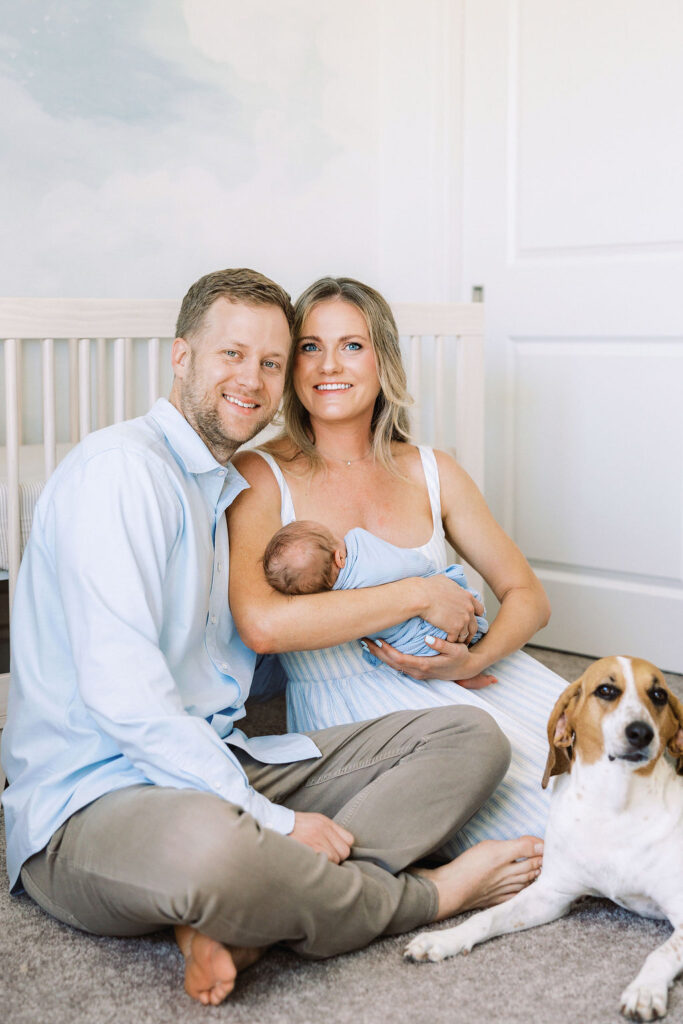New parents cuddling their baby together at home.