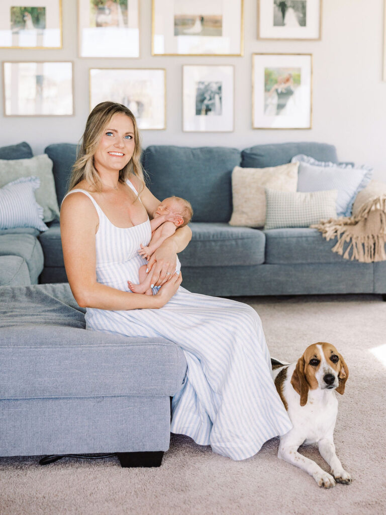 Mother holding her baby while sitting on the couch in the living room.