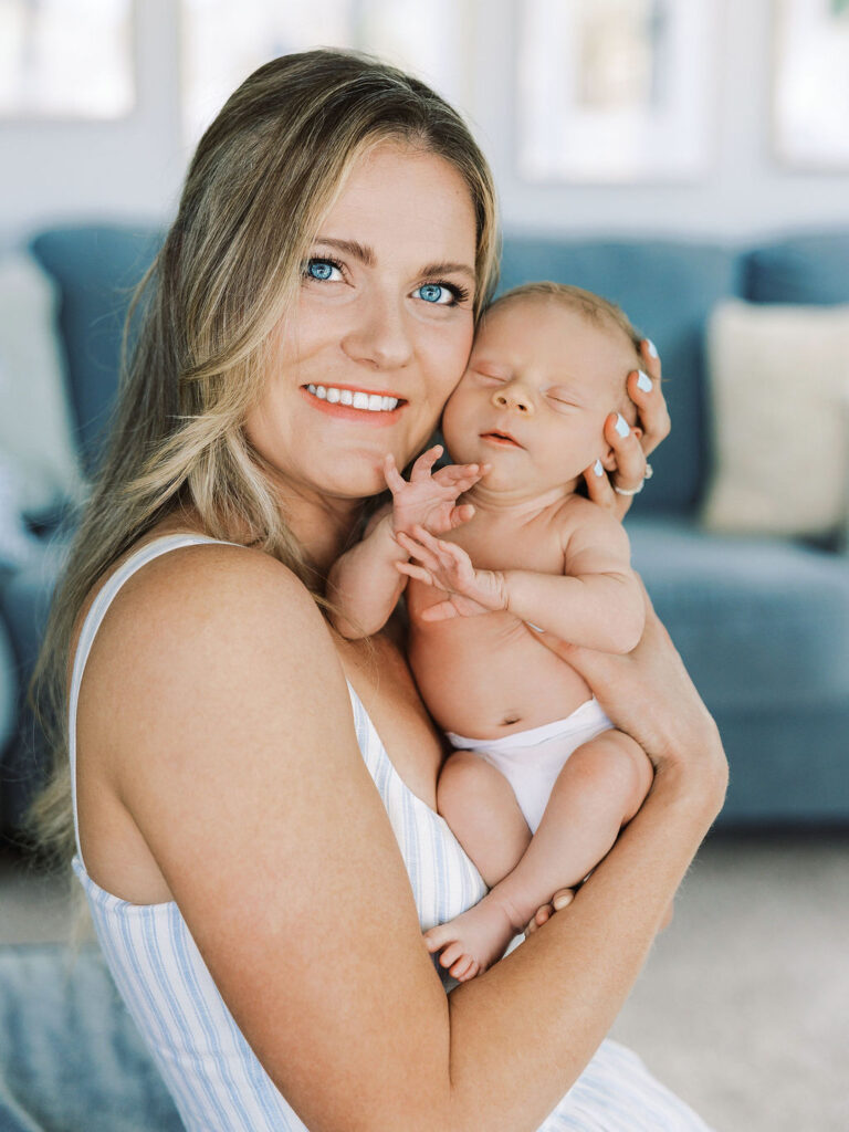 Mom cuddling her newborn cheek to cheek during in-home newborn photography Santa Clarita.