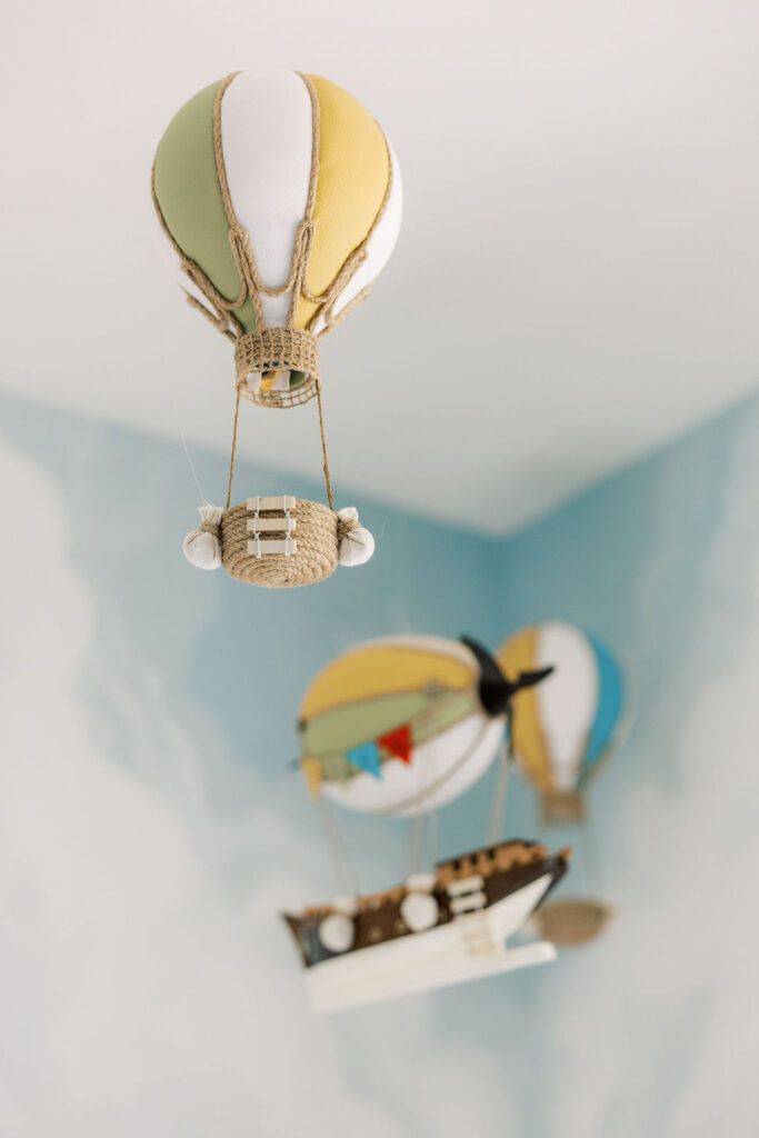 Colorful hanging nursery mobile above a newborn’s room.