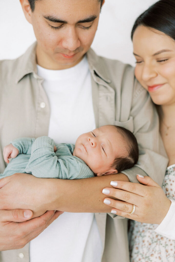 Close up family moment with parents cuddling their newborn baby