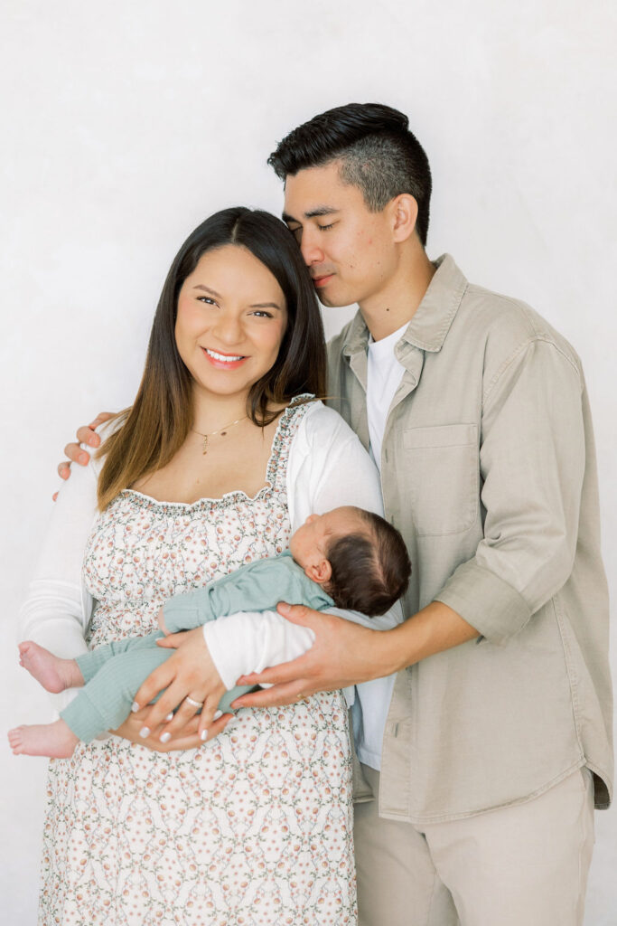 Mom and dad holding their newborn baby together during a lifestyle session