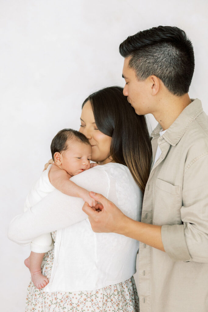 New parents with their baby during a studio newborn photography session