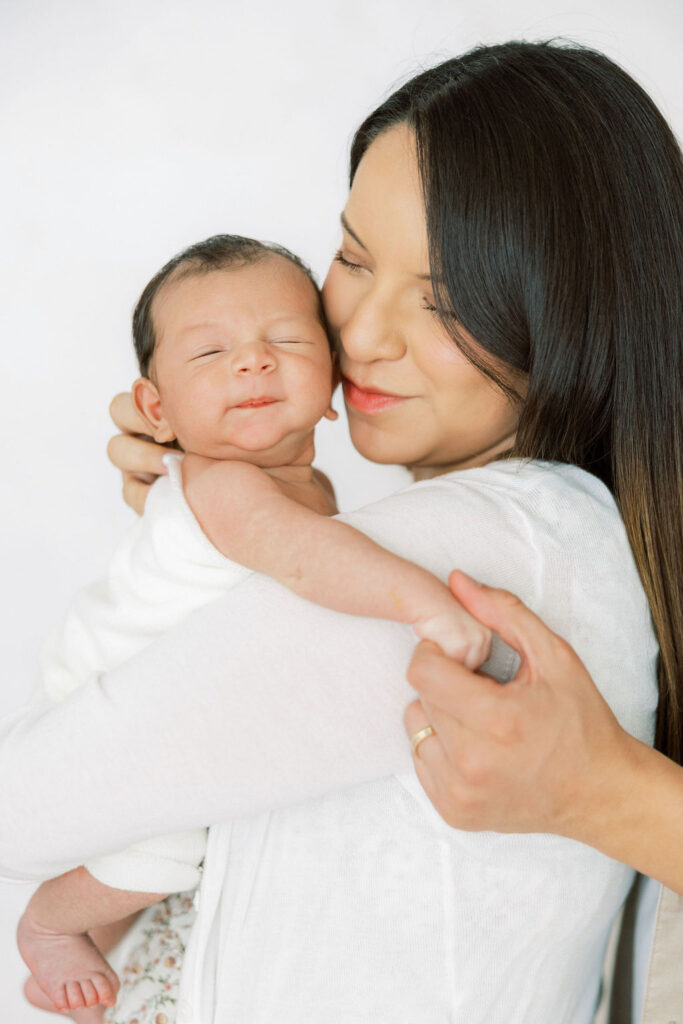 Close up of mom cuddling her newborn baby during a studio session