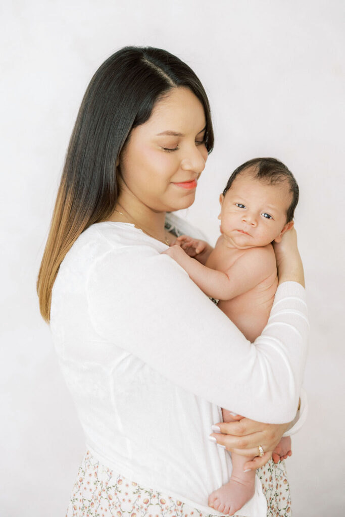 Mother holding her newborn close during an intimate lifestyle newborn session