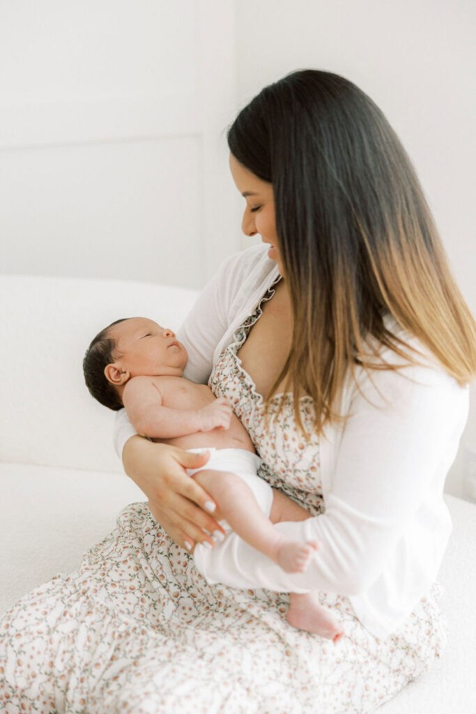 Mom snuggling her newborn baby during a studio photography session