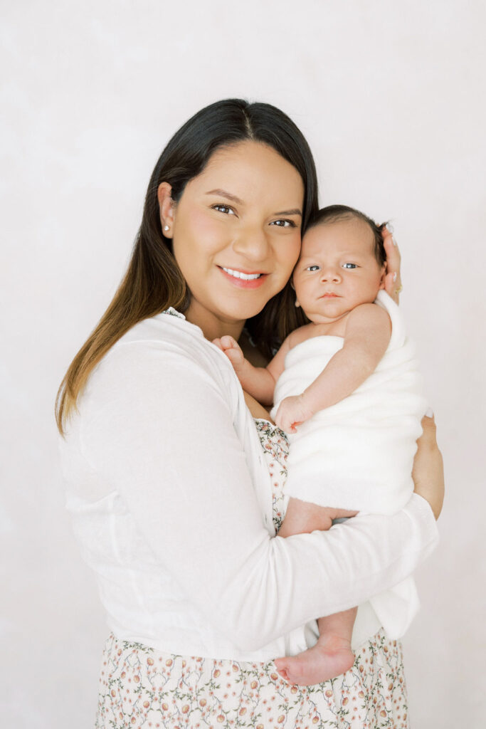 Mom holding her newborn baby during a studio lifestyle newborn session