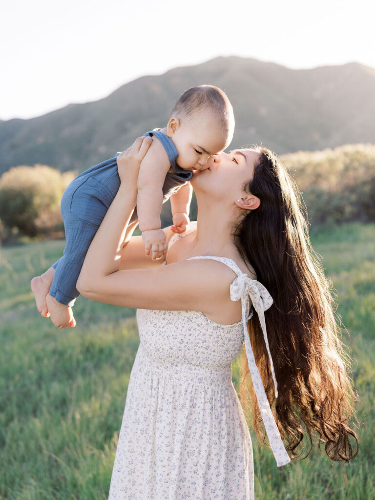 Mom holding her young child during natural family photos with kids