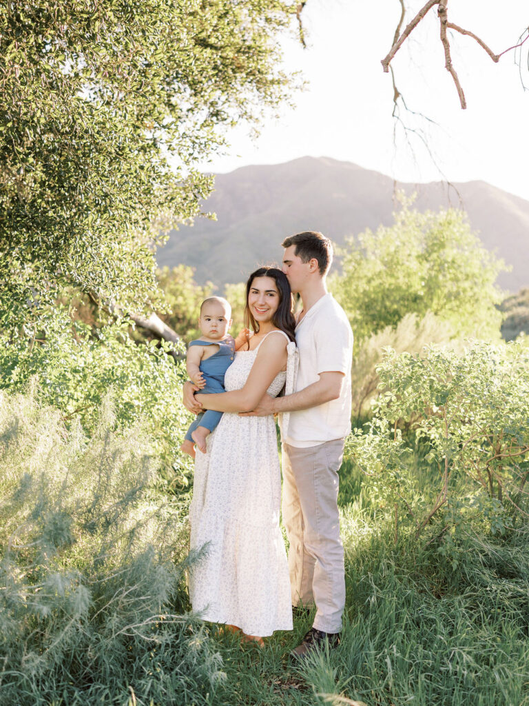 A family of three standing under a tree during a scenic Santa Clarita family session