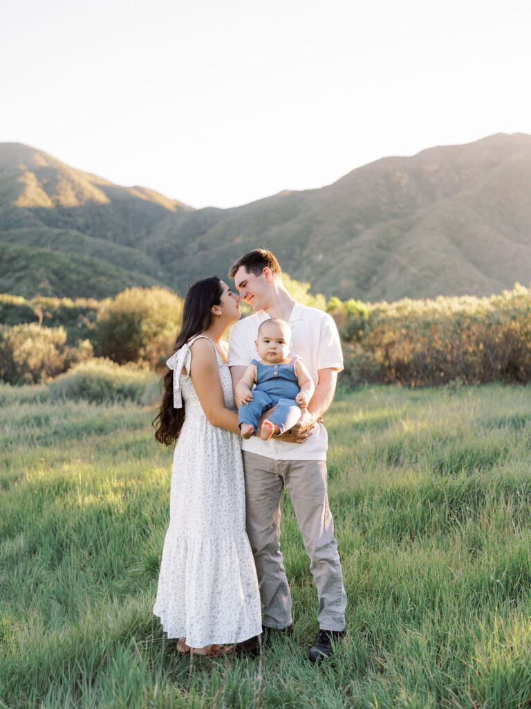 Mom and dad holding their baby during an outdoor family photo session