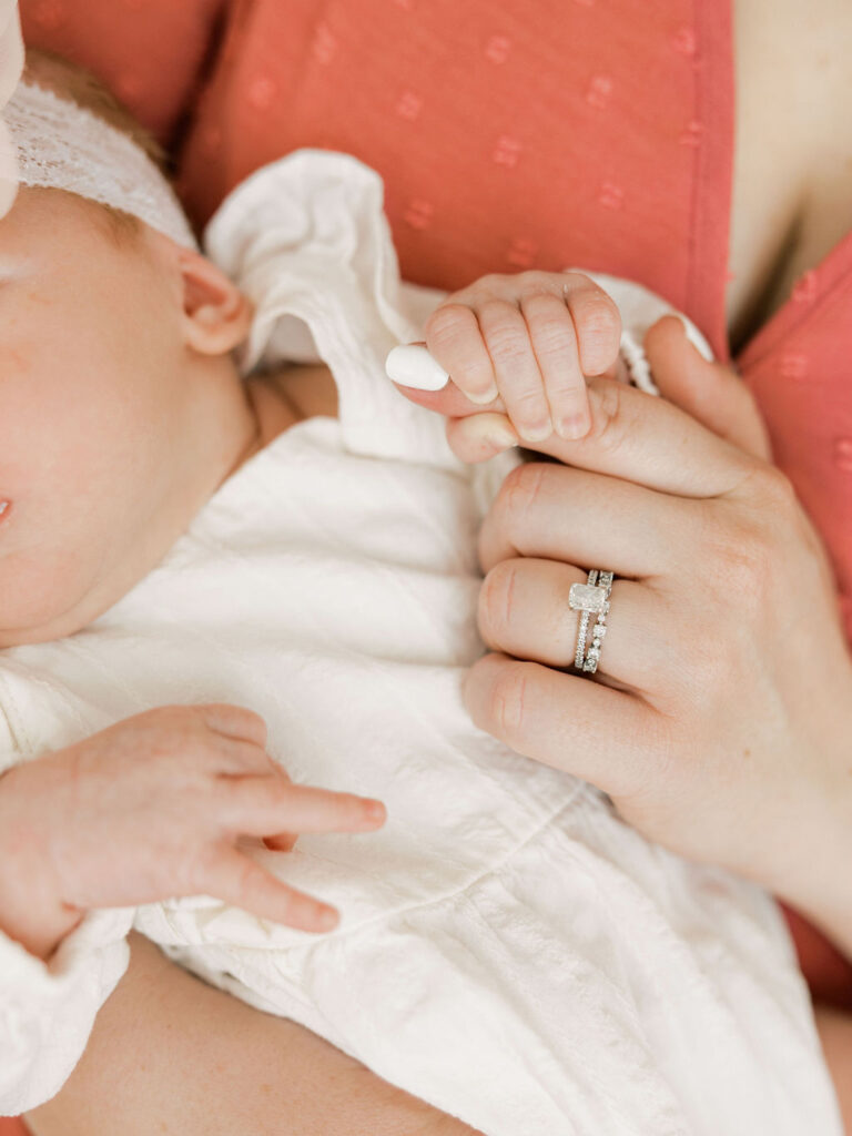 Close detail of a newborn baby holding Mom’s finger during a relaxed newborn photography session.