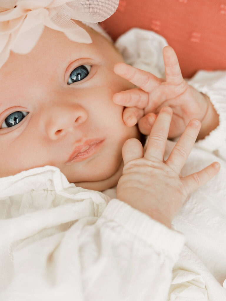 Close portrait of a newborn baby girl with bright eyes and tiny hands during Santa Clarita newborn photography.
