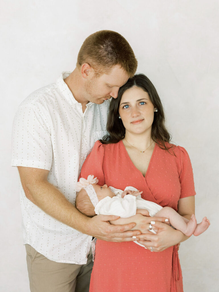 Mom and dad holding their newborn baby girl together during newborn photos in Santa Clarita.