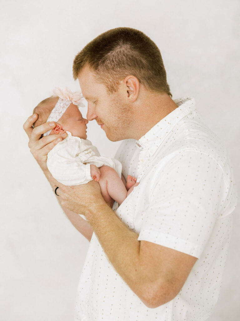 Dad gently touching noses with his newborn baby girl during newborn photos in Santa Clarita.