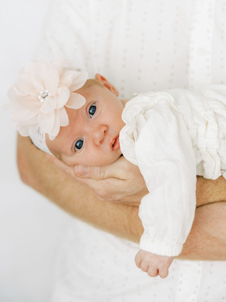 Newborn baby girl resting in a parent’s arms during newborn photos in Santa Clarita.