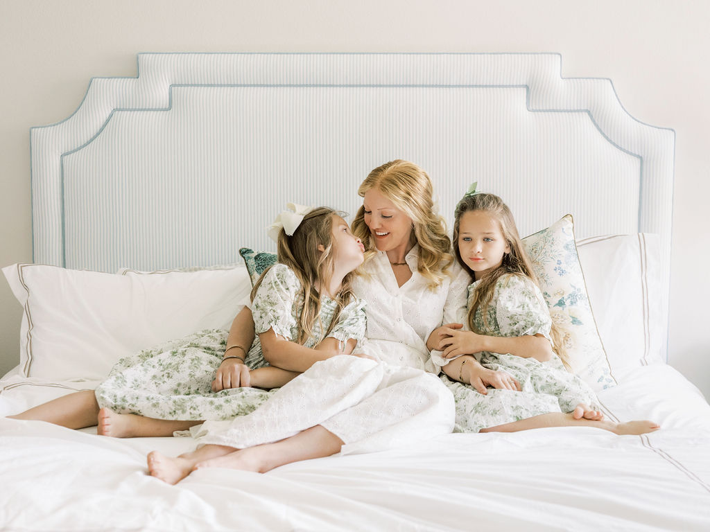 Mother sitting on the bed with her children during a newborn session with siblings