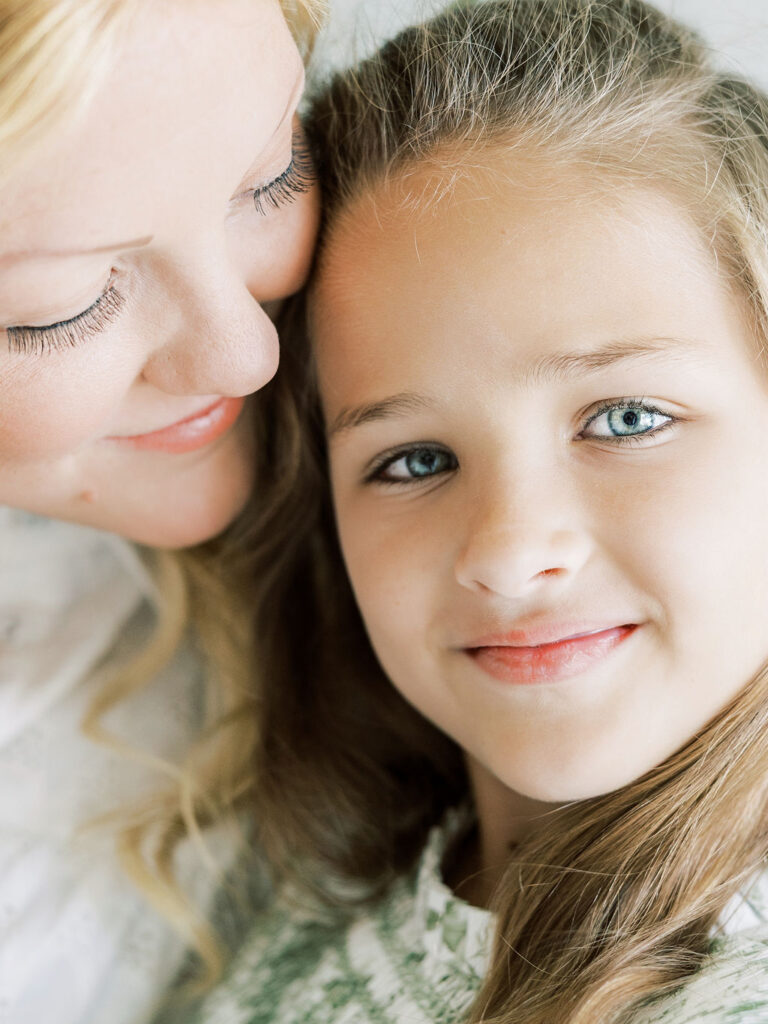 Mom sharing a close, affectionate moment with her older daughter during a newborn photos with siblings session.