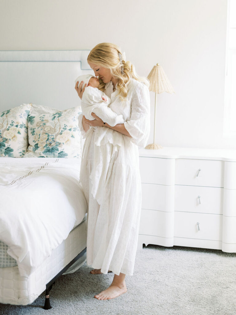 Mom holding her newborn baby in a soft white outfit during a Santa Clarita newborn session