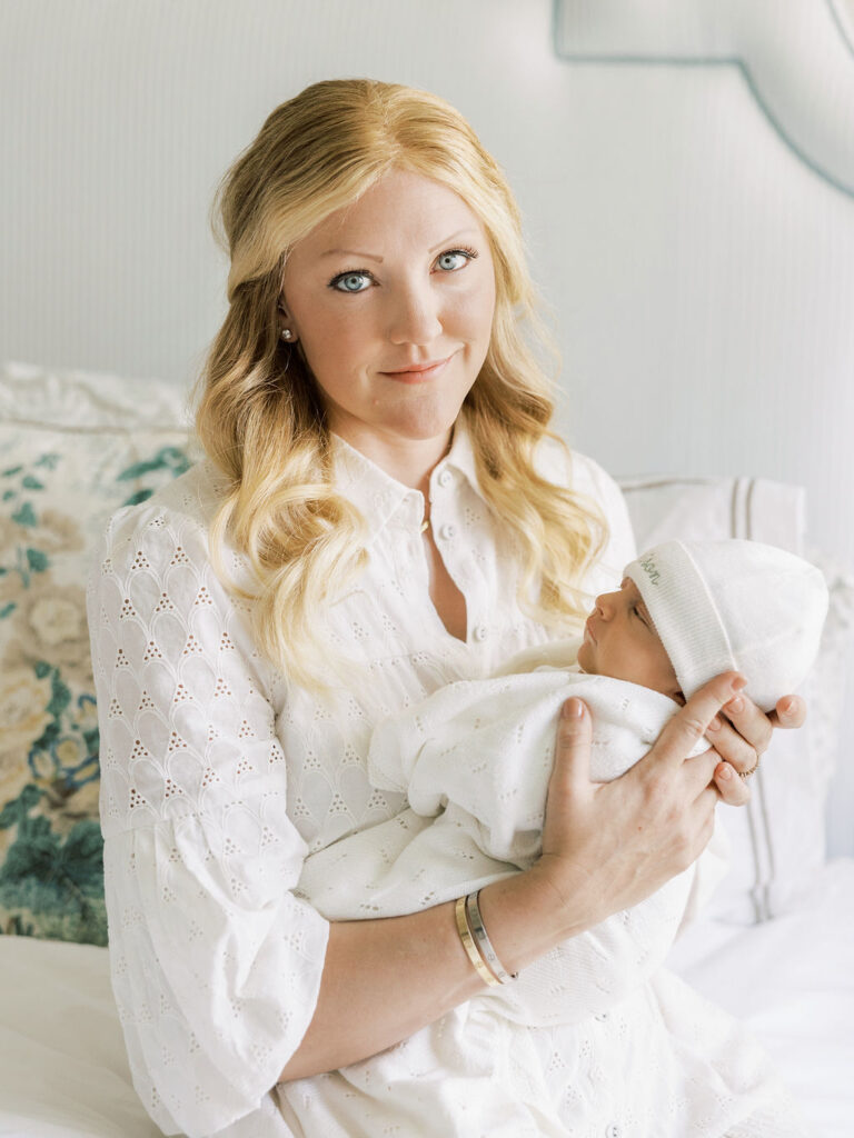 Mom in a white dress holding her sleeping newborn baby during a soft, natural Santa Clarita newborn photography session.