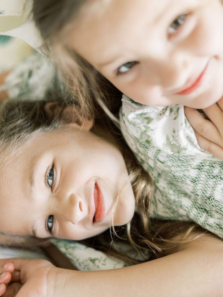 Older sibling lying beside the newborn baby during newborn sibling photography
