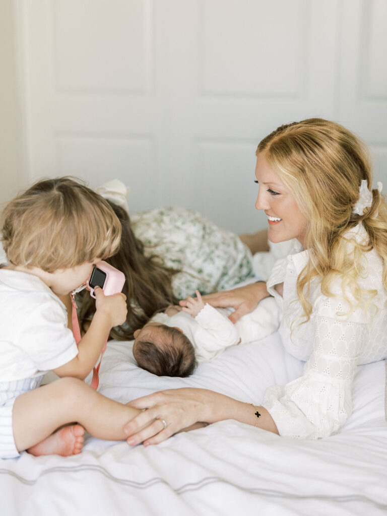 Older sibling looking at the new baby during newborn photos with siblings