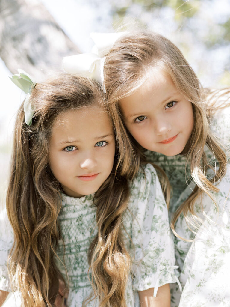 Two sisters cuddling together during a relaxed family newborn session