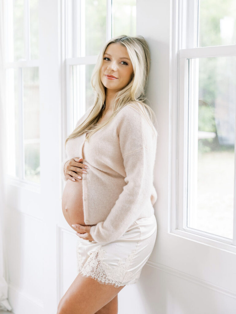 Expecting mom relaxing on a bed while preparing for her maternity photo session in Santa Clarita
