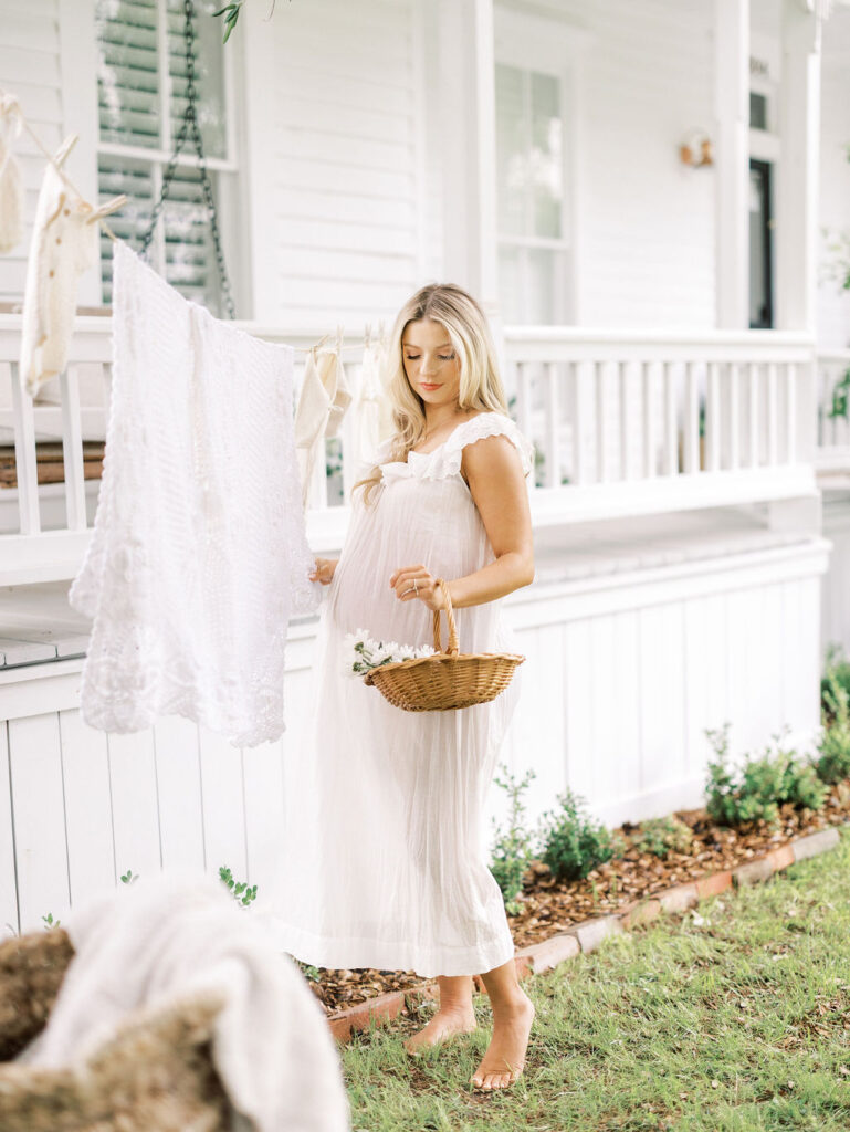 Expecting mom posing outdoors in a light dress while preparing for maternity photos in Santa Clarita