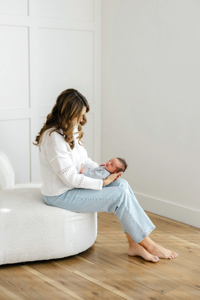 Mom sitting with her newborn baby during a peaceful Santa Clarita studio newborn session