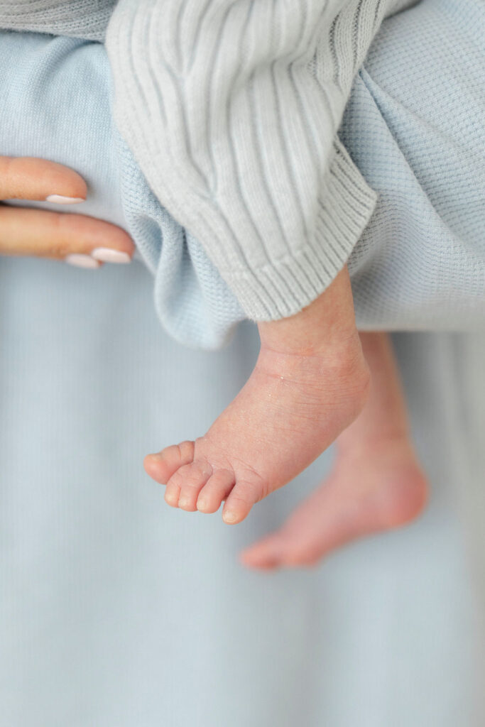 Close up of a newborn baby’s tiny feet during a relaxed studio newborn photography session.