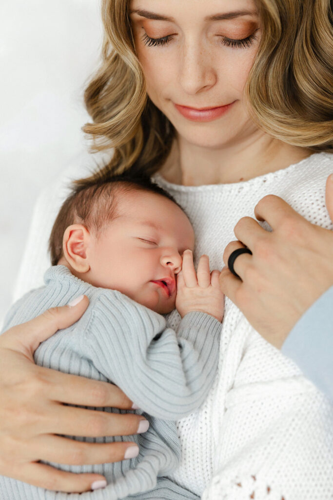 Mother holding her newborn baby close during a natural family moment