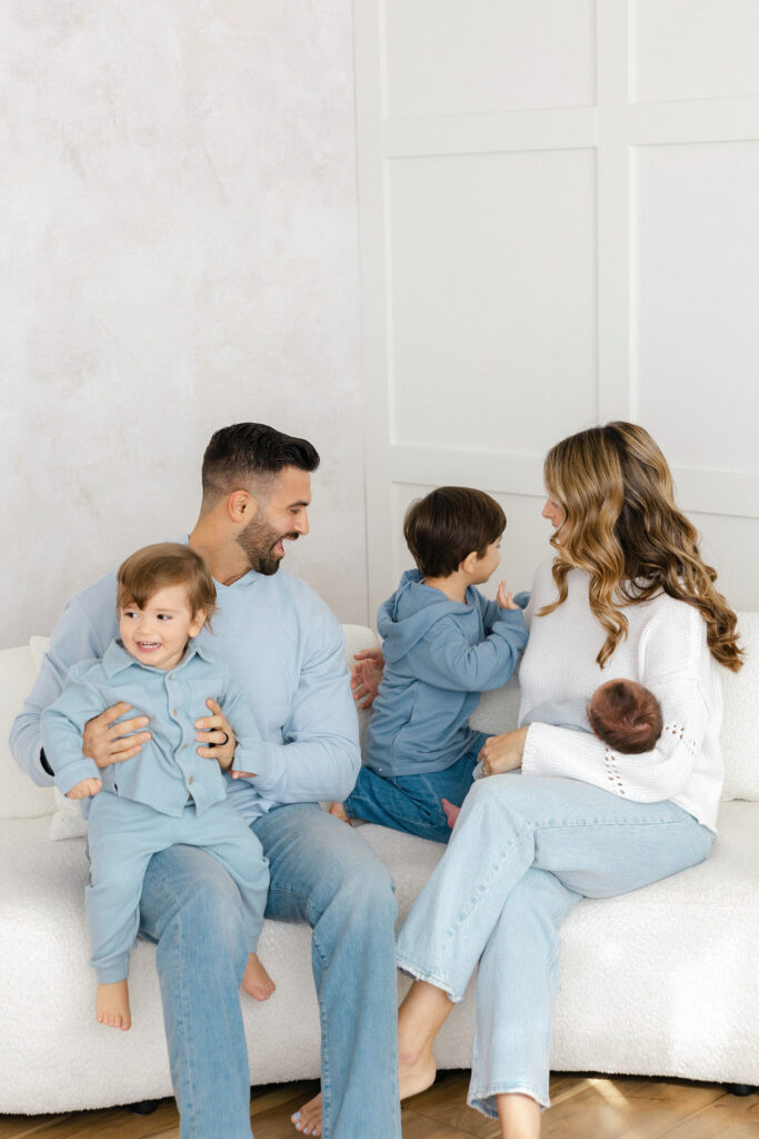 Family sitting together on the couch during a relaxed newborn photography session