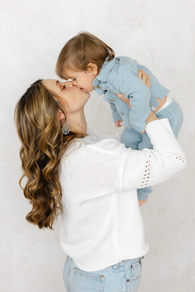 Mom kissing her child during a lifestyle newborn photography session