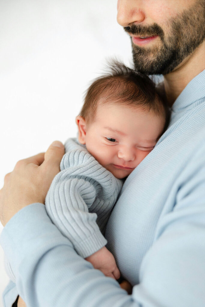 Newborn baby cuddled close during a relaxed studio newborn session
