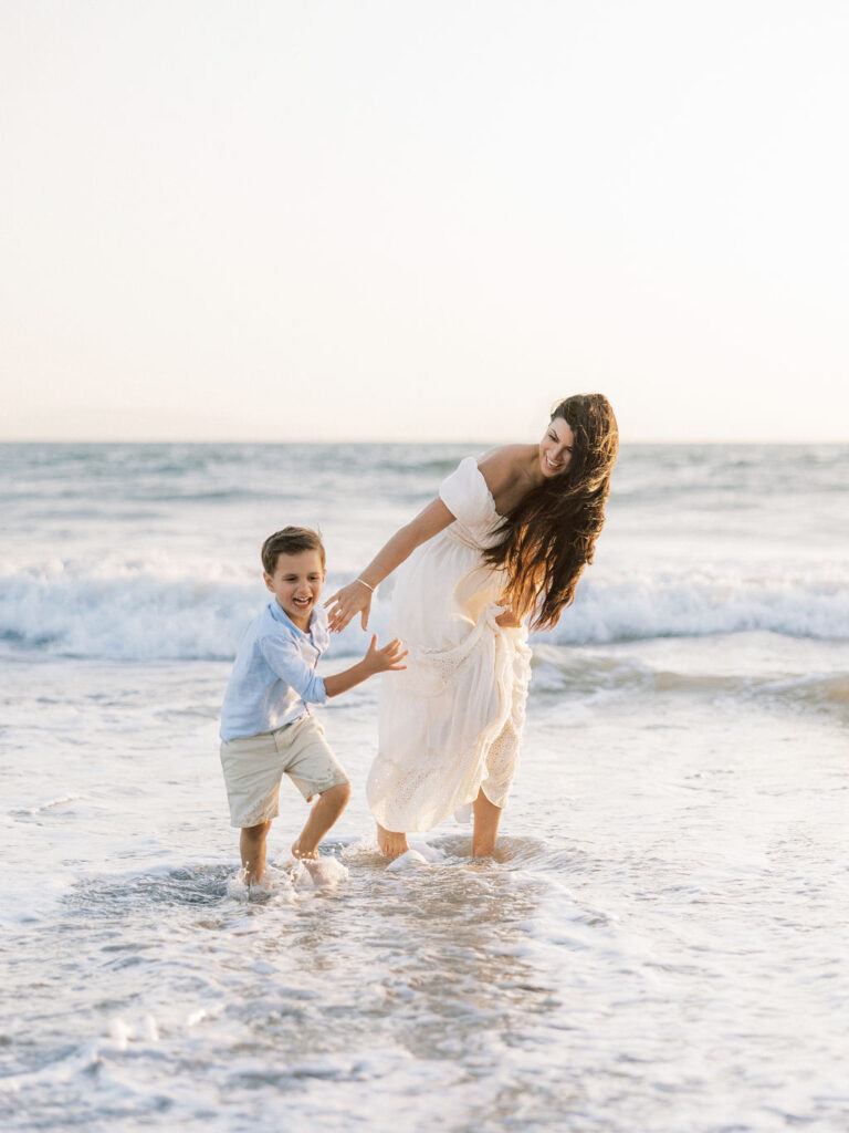 Mom and son playing in the ocean during a Ventura beach family photo session