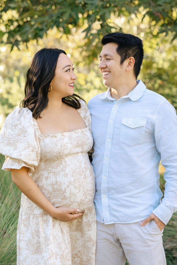Expecting couple sharing a quiet moment in coordinated outfits during their maternity session