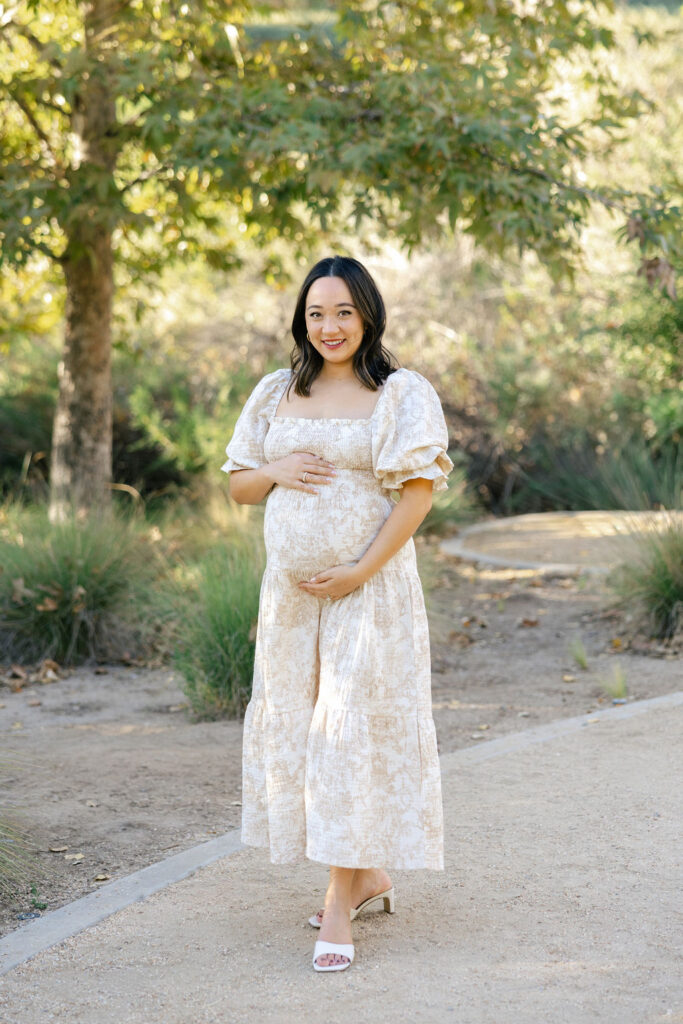 Close portrait of an expecting mom wearing a feminine off shoulder maternity dress